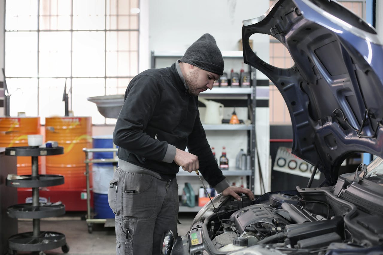 Avaleht Mechanic checking a car engine in a garage, ensuring quality maintenance and repair.
