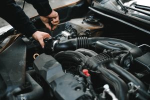 Avaleht Close-up of a mechanic working on a car engine. Ideal for auto repair themes.
