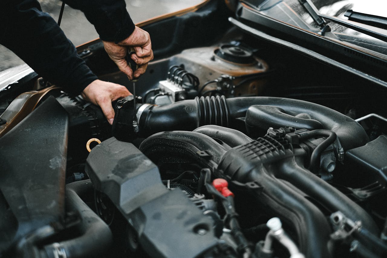 Avaleht Close-up of a mechanic working on a car engine. Ideal for auto repair themes.